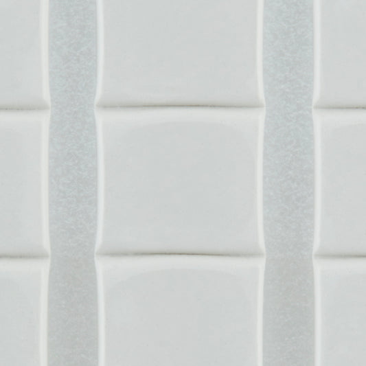 Nahaufnahme von weißen, glänzenden, rechteckigen Fliesen mit leicht erhabenen Kanten, die vertikal mit dünnen Fugenlinien angeordnet sind - sicher befestigt mit 3M Deutschland GmbH Scotch-FIX™ Ablösbare Klebepads 301008C36-P (11 mm x 15 mm, 36 Stück/Packung).