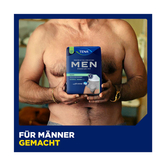 Ein Mann ohne Hemd hält eine Schachtel Muster TENA Men Active Fit Pants Normal Grey von TENA - Essity Germany GmbH in Brusthöhe. Der Text "Für Männer gemacht" betont den diskreten Schutz und Komfort für Männer mit Inkontinenz - für Männer gemacht.