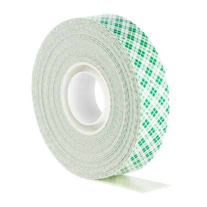 Banda de montare interioară dublu adezivă Scotch-FIX™ de la 3M Deutschland GmbH are un miez alb cu model caroiat verde și este prezentată vertical cu o mică parte din bandă vizibilă.