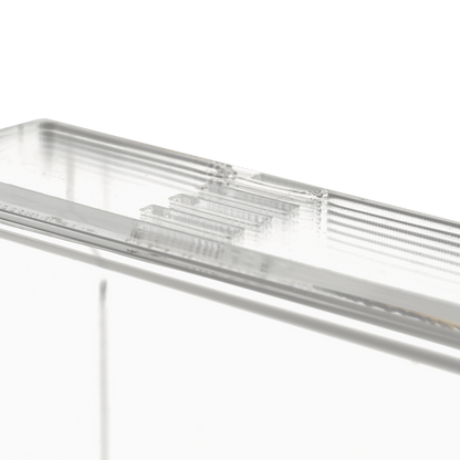 Prim-plan al dispenserului transparent, lăptos, pentru mănuși de unică folosință (250 x 135 x 55-90 mm) de la AMPri Handelsgesellschaft mbH, un suport dreptunghiular din acril cu margini canelate pe un fundal alb simplu.