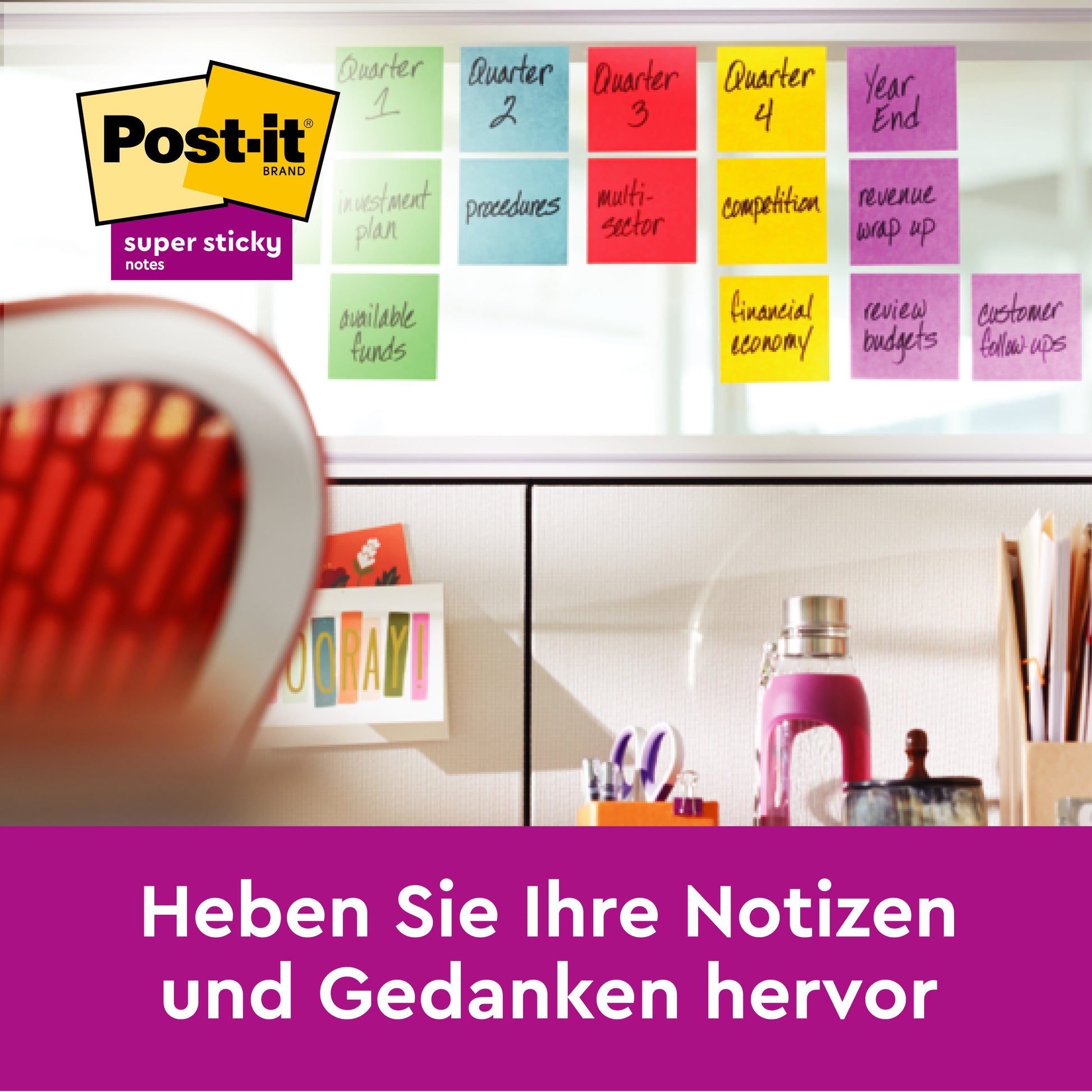 Im Vordergrund steht ein Schreibtisch mit Büromaterial. Dahinter sind auf einer Glaswand bunte Post-it® Super Sticky Notes der 3M Deutschland GmbH in verschiedenen Farben und Größen (45 Blatt/Block, 3 Blöcke) angeordnet. Darüber sind das Post-it Logo und der deutsche Text zu sehen.