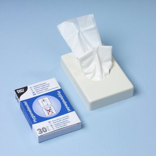 Un distribuitor alb de batiste se află lângă o cutie distribuitoare Starpak de 30 de pungi igienice (28,5 x 8 x 7 cm, alb), care conține 30 de pungi igienice cu imagini de instrucțiuni pe o suprafață albastru deschis.