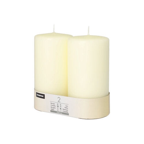 Două lumânări Starpak, Ø 80 mm, cu cap plat, stau în suportul simplu de carton cu etichetă – o notă de eleganță atemporală pentru orice ambianță.