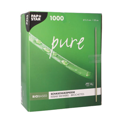 O cutie verde cu inscripția "PAPSTAR frigărui de lemn 'pure', Ø 3,5 mm, 20 cm lungime | Suport de carton (1000 bucăți)" de la PAPSTAR GmbH conține 1000 de frigărui de lemn și arată o imagine cu un frigăruie cu picături de apă pe un fundal verde aprins.