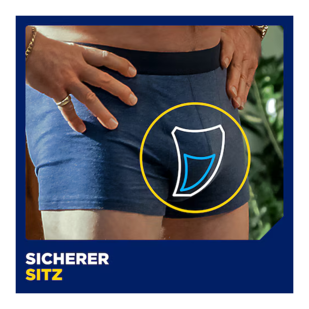 Ein Mann in blauen Boxershorts steht mit den Händen in den Hüften. Eine Grafik hebt den Schritt mit einem weißen und blauen Polster hervor, was auf Muster TENA Men Active Fit von TENA - Essity Germany GmbH hinweist. Der Text lautet: "Sicherer Sitz.