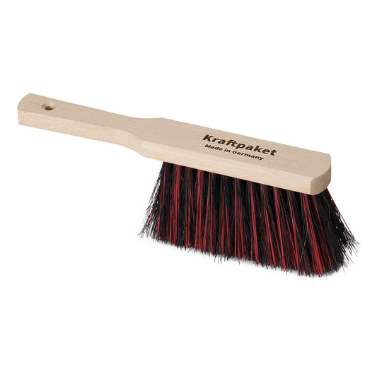 Der Nölle Profi Brush Handfeger 30 cm aus Arenga/Elaston von Nölle Profi Brush Bürsten- & Pinseltechnik e.K. hat einen hellen Holzstiel mit "Kraftpaket Made in Germany" und schwarz/rote Borsten, abgebildet auf weißem Grund.
