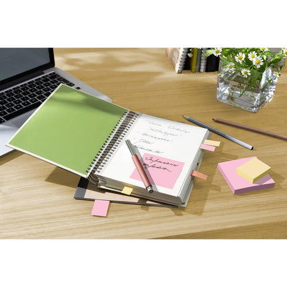 Un caiet cu notițe scrise de mână și note reciclabilă Post-it® 3M (38 mm x 51 mm, 100% PEFC) este deschis pe o masă de lemn lângă un laptop, pixuri și o vază cu margarete albe.