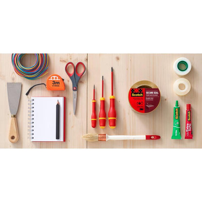 Diverse unelte și articole de papetărie, inclusiv un dispenser 3M cu mâner tip pistolă + bandă adezivă de ambalare Scotch (50 mm x 66 m, 1 distribuitor + 2 role), foarfecă, spatulă, bandă de măsurat, tuburi de lipici, blocnotes cu creion, sârme și pensule sunt expuse pe lemn.