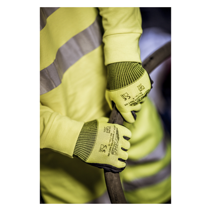 O persoană care poartă o vestă de avertizare galbenă și mănuși din nailon NITRAS NYLOTEX SOFT HV de la AS Arbeitsschutz GmbH, galben neon, parțial acoperite – cu text negru și simboluri de siguranță – ține un cablu sau un furtun gros și întunecat.