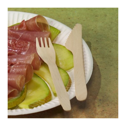 O farfurie de carton alb cu felii de măr verde și prosciutto, alături de PAPSTAR furculițe din lemn "pure" 16,5 cm - ecologice și stabile (100 bucăți) - de la PAPSTAR GmbH, și un cuțit din lemn, pe un fundal verde.