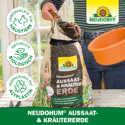 O persoană umple un ghiveci portocaliu cu NeudoHum Aussaat- & KräuterErde de la Neudorff Shop - un pământ de semănat și ierburi biologic, prietenos cu animalele de companie, în ambalaj din bioplastic, ideal pentru ierburi mediteraneene.