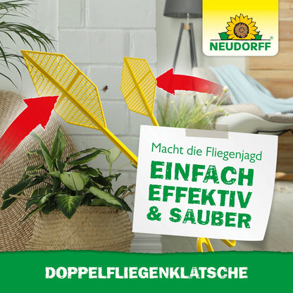 Două Doppelfliegenklatschen galbene de la Neudorff Shop cu săgeți roșii sunt expuse într-un interior lângă o plantă. Pe un semn german scrie: "Simplu, eficient & curat, prinde muște fără pete", deasupra logo-ul mărcii.