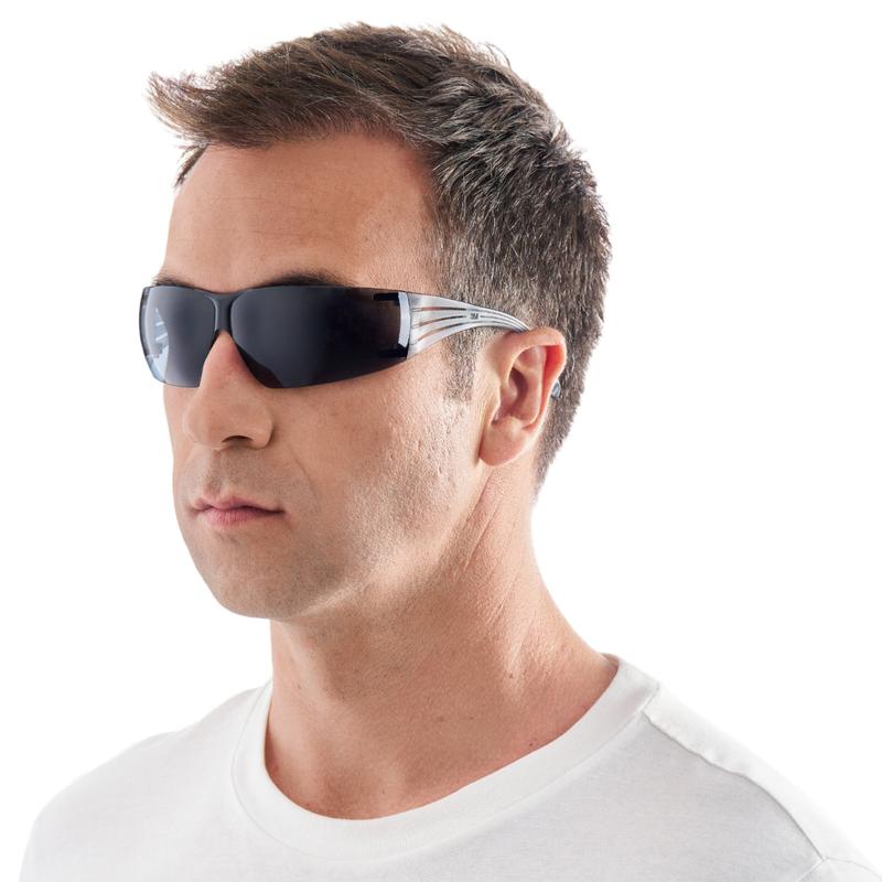 Un bărbat cu păr scurt castaniu, într-un tricou alb, poartă ochelarii de protecție 3M™ SecureFit™ 200 de la 3M Deutschland GmbH, ușor orientat spre stânga pe un fundal alb simplu.