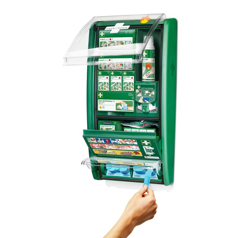 O stație de prim ajutor și arsuri Cederroth de la Orkla Wound Care AB montată pe perete este deschisă și arată consumabile precum bandaje, instrucțiuni, sticle pentru clătirea ochilor și o mână care ia o capsulă albastră pentru clătirea ochilor din compartimentul inferior. (1 pachet/cutie).