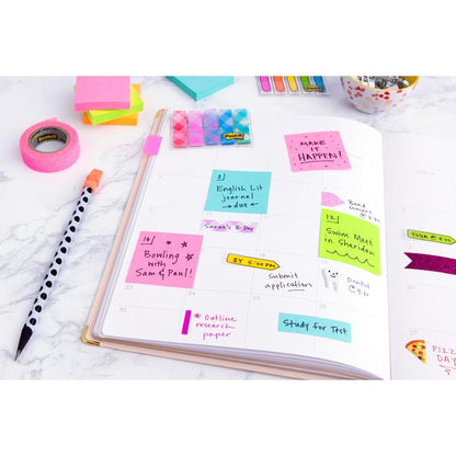 Un planificator deschis cu un cub de notițe Post-it® colorate (76 mm x 76 mm, 450 foi/bloc, 100% PEFC) de la 3M Deutschland GmbH cu amintiri scrise de mână. În apropiere se află stilouri, bandă Washi, alte notițe adezive și agrafe pe o suprafață albă.