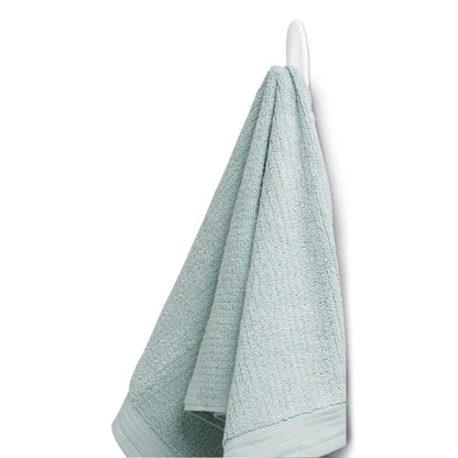 Ein hellblaues, strukturiertes Handtuch hängt an einem Command™ Bad Medium Designer-Haken, 17081B von 3M Deutschland GmbH an einem weißen Wandhaken, vor einem schlichten weißen Hintergrund.