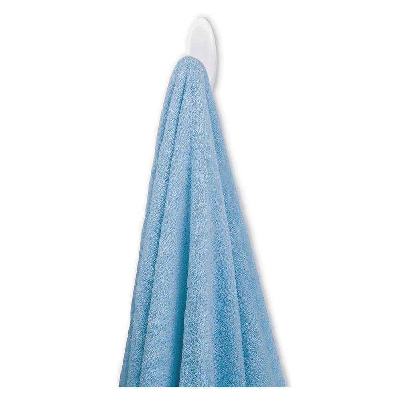 Un prosop albastru atârnă de un cârlig pentru prosoape de baie Command™ de la 3M Deutschland GmbH pe un cârlig alb în fața unui fundal alb.