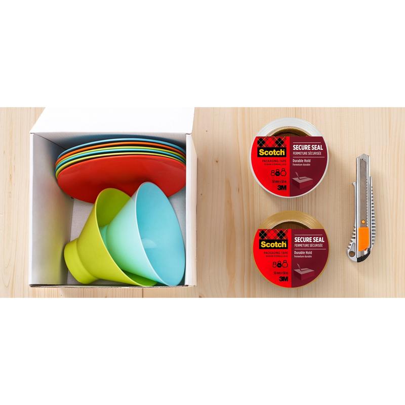 În stânga se vede o cutie de carton cu farfurii și boluri din plastic colorate stivuite. În dreapta sunt două role de bandă adezivă de ambalare Scotch® de la 3M Deutschland GmbH pentru o închidere sigură (50 mm x 50 m) și un cutter universal pe lemn.