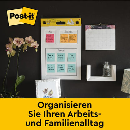 Un perete de birou cu chartul de întâlniri autoadeziv Post-it® Super Sticky 559 de la 3M Deutschland GmbH (63,5 x 76,2 cm), calendar lunar, raft cu sticlă, orhidee și fotografii. Text: "Organizați-vă viața de zi cu zi.