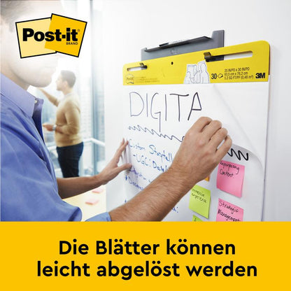 O persoană scrie pe un Post-it® Super Sticky autoadeziv Meeting Chart/Flipchart de la 3M Deutschland GmbH pentru montare pe perete 566 (58,4 x 50,8 cm, alb), care este fixat cu benzi Command™ pe o tablă albă; notițe adezive colorate sunt atașate pe acesta.