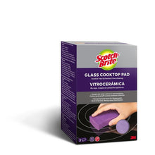 O cutie de bureți de curățat pentru plite din sticlă ceramică 3M Scotch-Brite™ (3 bucăți) prezintă o mână care curăță o plită din sticlă ceramică cu un burete violet. Pe ambalaj se specifică faptul că produsul nu zgârie și nu conține substanțe chimice, fiind ideal pentru suprafețele din sticlă ceramică.