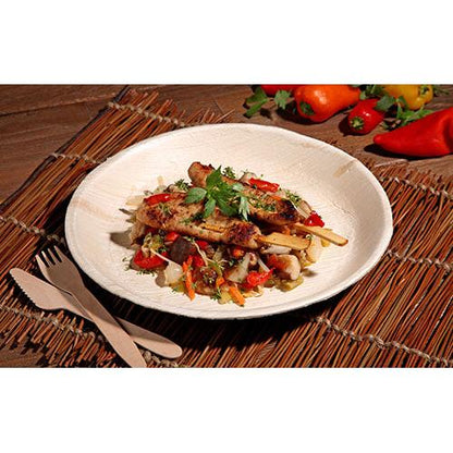 Frigărui de carne la grătar cu legume mixte și ierburi sunt servite pe o farfurie rotundă „pure“ 25 din frunză de palmier de la PAPSTAR GmbH, cu veselă de unică folosință ecologică și ardei colorați și legume în fundal.