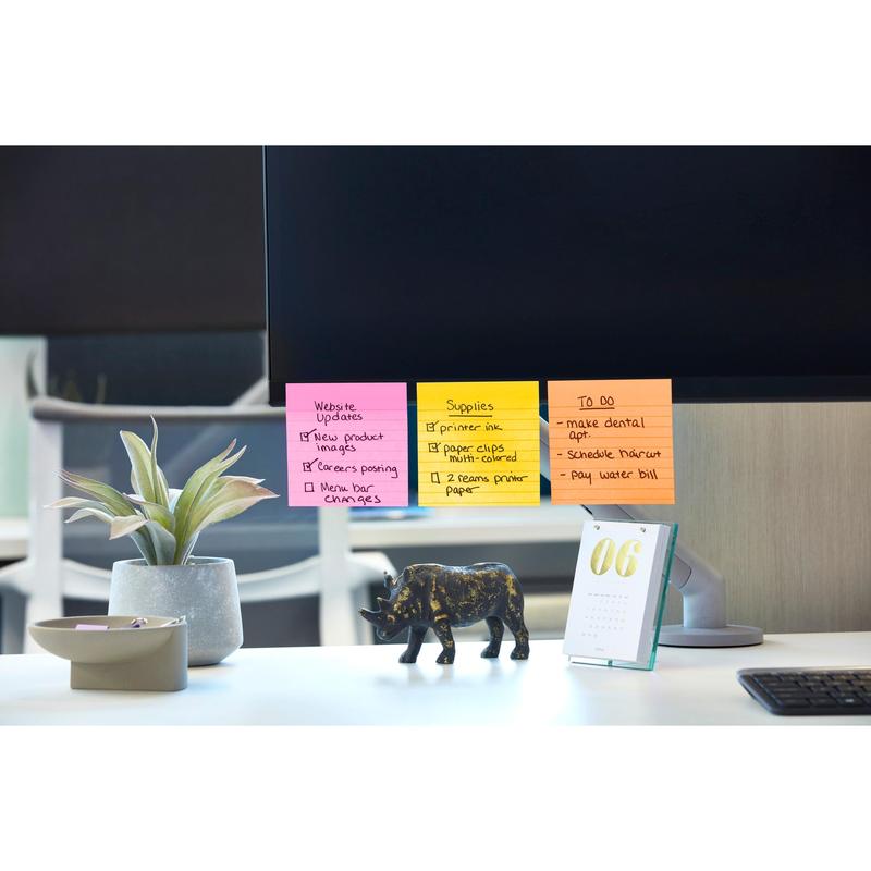 Un monitor de computer afișează Post-it® Super Sticky Notes colorate în format mare (101 mm x 101 mm, 90 foi/bloc, 100% PEFC) de la 3M Deutschland GmbH cu actualizări de site, materiale și sarcini. Pe birou se află o plantă, o figurină de elefant negru și un calendar de birou cu anul "06".