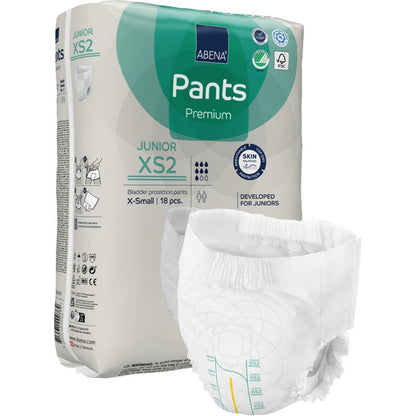 Un pachet de ABENA Pants Junior Premium, Gr. XS2 de la Abena Re-Seller GmbH este prezentat cu un scutec nepliat în prim-plan. Pachetul bej cu accente verzi și albastre conține 18 bucăți X-small.