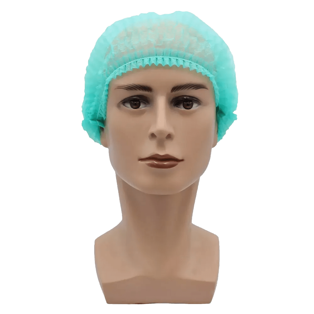 Pe un fundal simplu alb, este ilustrat un cap de păpușă bej cu expresie facială neutră și păr scurt și închis la culoare, acoperit de o plasă AMPri MED-COMFORT Klipphaube 52 cm, în verde deschis, din polipropilenă de la AMPri Handelsgesellschaft mbH. Căciula oferă protecție igienică.