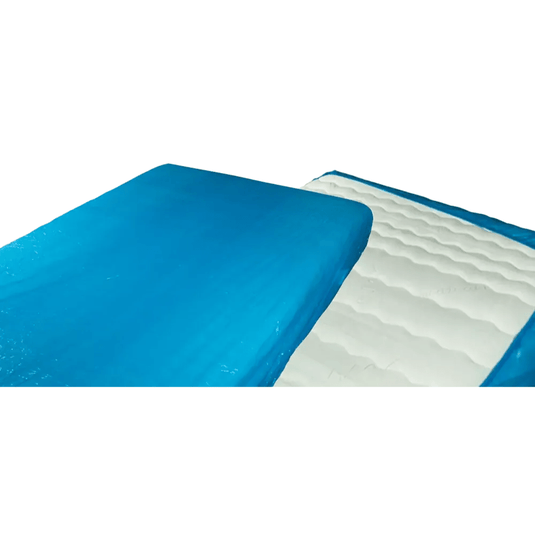 Prim-plan al unei huse de saltea din gel albastru-alb, asemănătoare cu husa de saltea de unică folosință AMPri MED-COMFORT PE cu elastic, de 210 x 90 x 20 cm, produsă de AMPri Handelsgesellschaft mbH. Partea albastră acoperă cea mai mare parte a suprafeței superioare, în timp ce partea albă prezintă o textură ondulată. Imaginea prezintă o porțiune pliată spre spate, similar cu protecțiile din polietilenă utilizate în spitale.