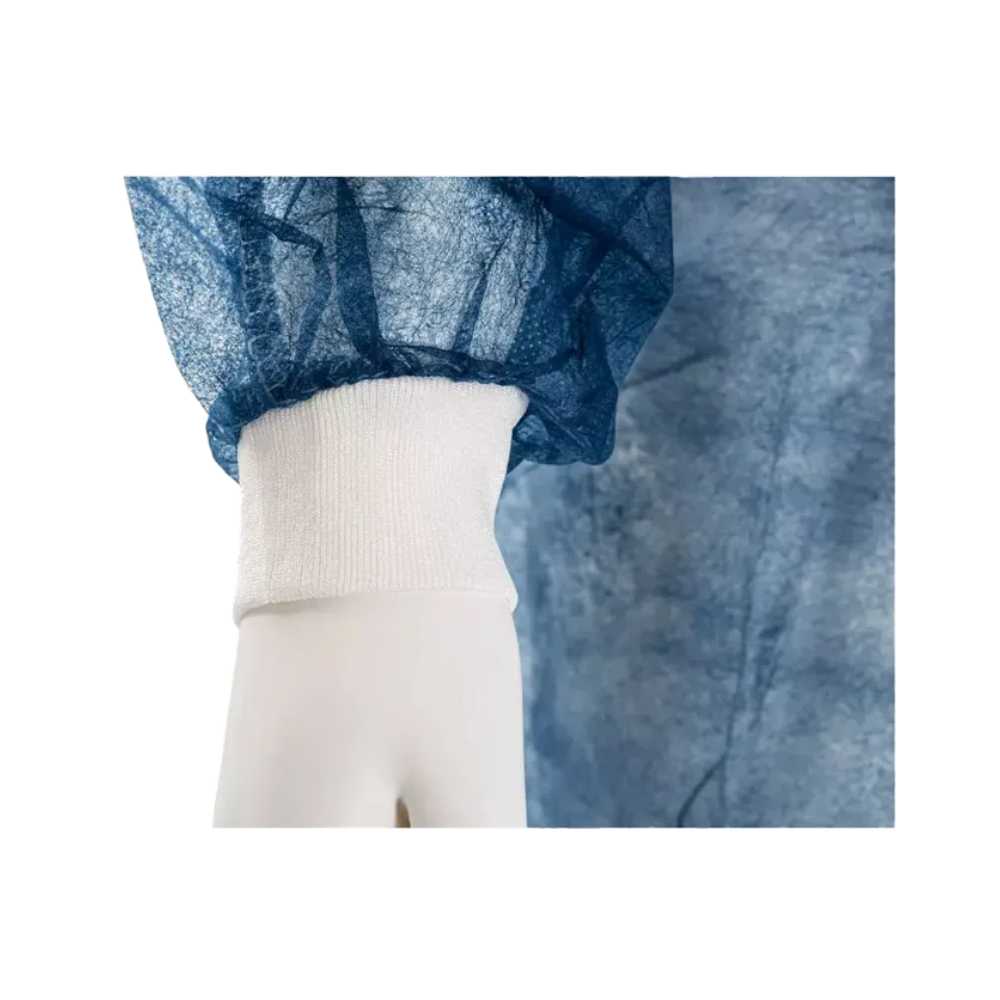 Prim-plan al mâinii unui manechin care poartă un articol vestimentar albastru, semi-transparent, cu o manșetă elastică albă. Acest halat de vizitator de unică folosință AMPri MED-COMFORT PP, cu manșete tricotate, fabricat de AMPri Handelsgesellschaft mbH, este realizat din material de polipropilenă încrețită și oferă o potrivire confortabilă în jurul încheieturii.