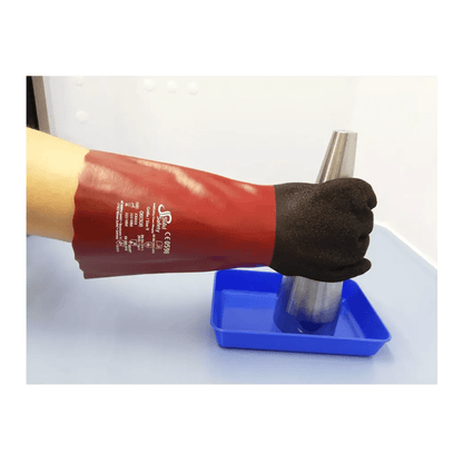 O persoană poartă o mănușă roșie AMPri SolidSafety Chem MaxGrip cu degete negre și marcaje albe și ține un con metalic deasupra unei tăvi albastre. Mănușa, cunoscută pentru protecția sa împotriva acizilor și rezistența la abraziune, se evidențiază pe fundalul simplu și luminos.