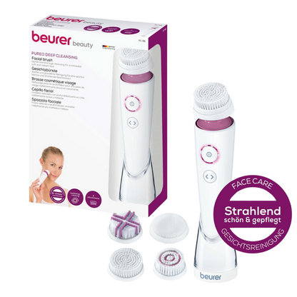 Imaginea arată un set de perie facială Pureo Deep Cleansing FC 95 de la Beurer GmbH, ambalat. Setul include dispozitivul principal pentru peria facială, trei capete de perie diferite, potrivite pentru fiecare tip de piele, și un mic semn rotund violet care evidențiază efectul de curățare profundă al îngrijirii și curățării feței.