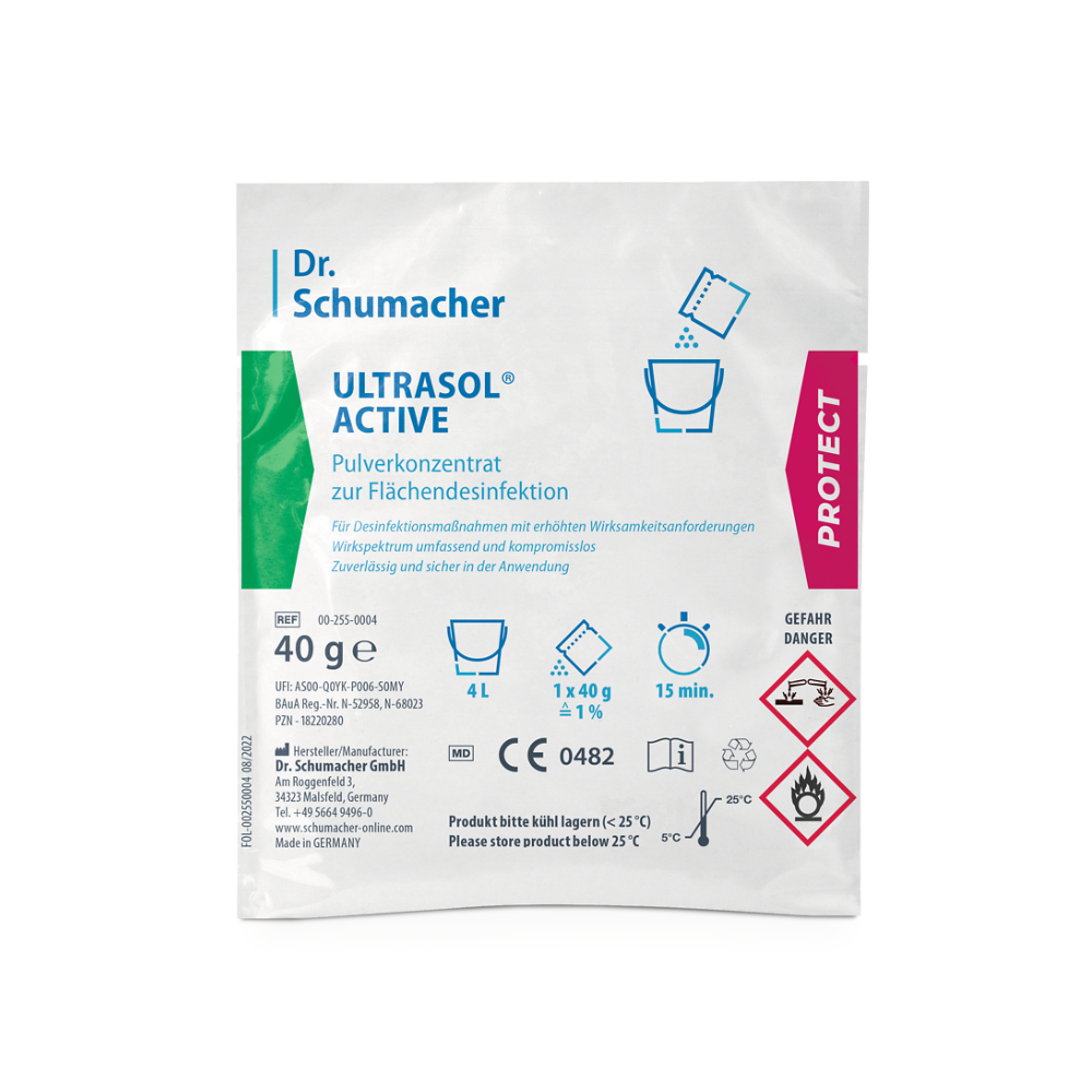 Un pachet Dr. Schumacher Ultrasol® Active Dezinfecție pentru suprafețe de la Dr. Schumacher GmbH conține concentrat de pulbere pentru dezinfecția suprafețelor. Pachetul alb cu accente verzi și roz conține text și simboluri care indică faptul că conține 40 de grame de concentrat de pulbere pentru dezinfecția suprafețelor și ar trebui să fie depozitat sub 25 °C. Pe ambalaj sunt de asemenea prezente simboluri de pericol.