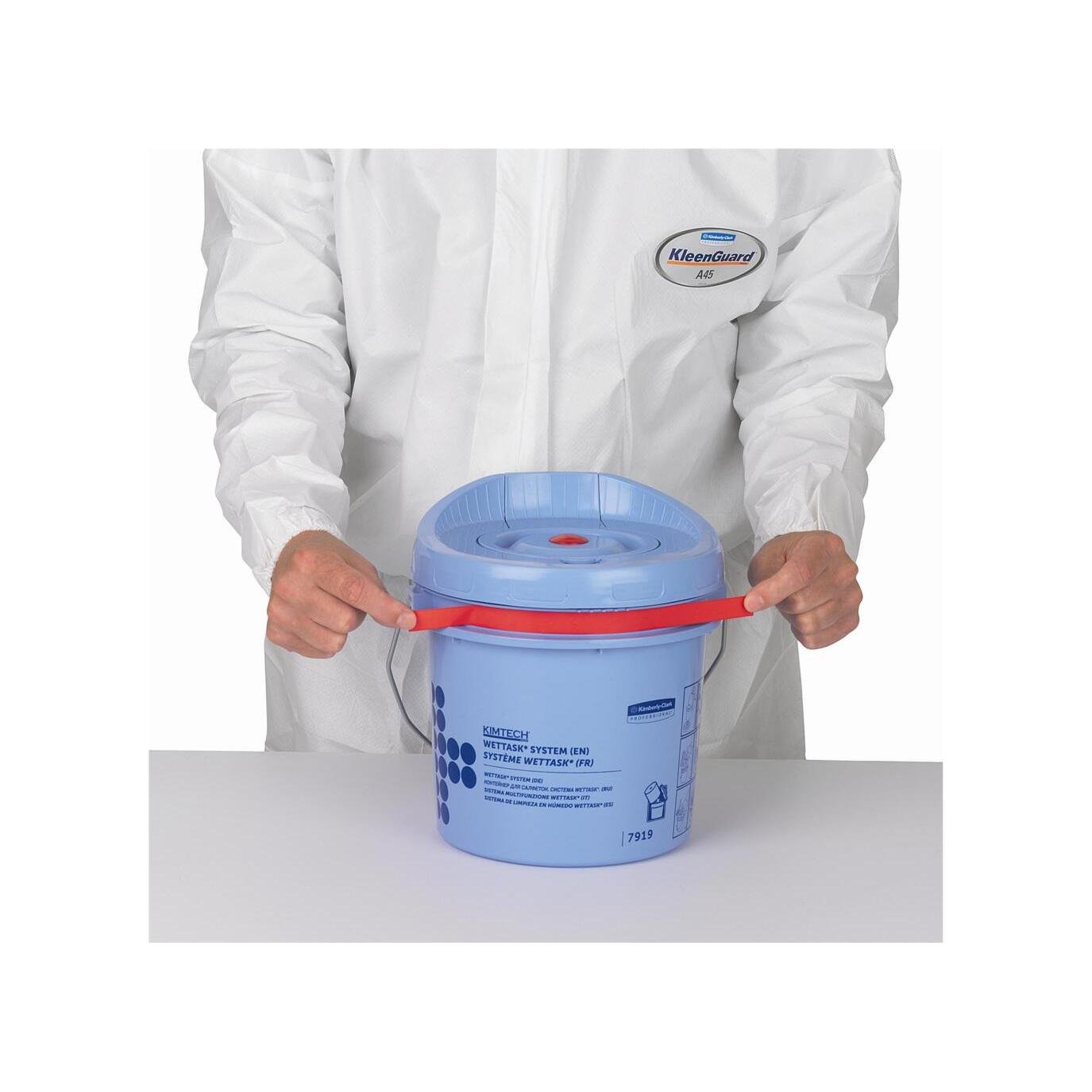 O persoană într-un costum alb KleenGuard ține o găleată distribuitoare de șervețele Kimtech® Wettask™ albastră de la Kimberly-Clark GmbH (găleată de curățare) cu un mâner roșu pe o suprafață albă.