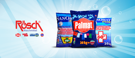 Drei große Waschmittelbeutel - Sanomat, Palmat und eine weitere Sanomat-Variante - stehen aufrecht vor einem blauen Hintergrund mit Seifenblasenmotiv, daneben das Logo von Rusch Waschmittel auf der linken Seite.