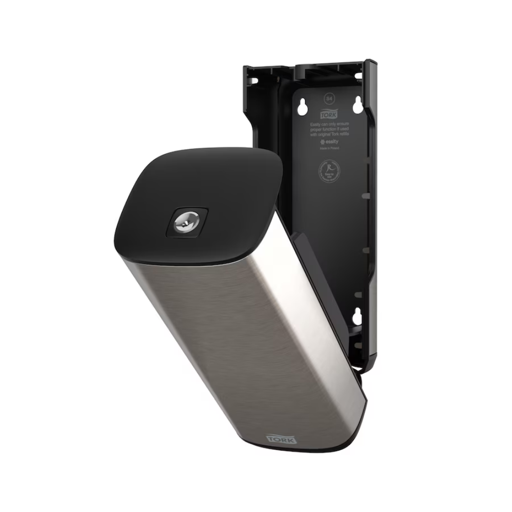 Ein Tork 460010 Spender für Seife und Handdesinfektionsmittel aus Edelstahl und Schwarz von Essity Professional Hygiene Germany GmbH zur Wandmontage mit offener Frontplatte, die den Blick auf das Innenfach freigibt. Dieses moderne Design weist außerdem eine teilweise abgelöste Platte auf, die die Innenhalterung und die Schraubenpositionen freigibt.