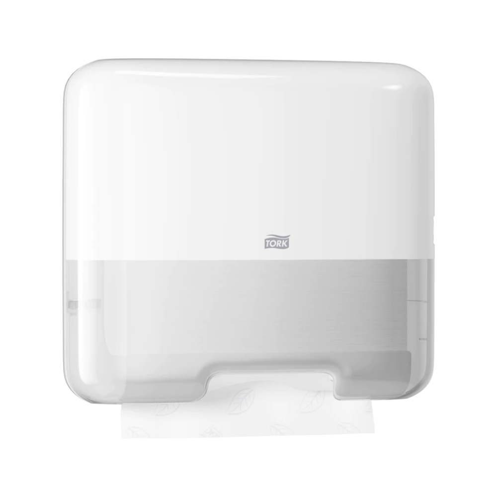 Dispenserul mini Tork 553100 pentru prosoape de mâini în zig-zag, proiectat în stilul modern Elevation H3, prezintă elegant marca „Tork” pe partea frontală. O zonă transparentă în partea de jos permite vizualizarea unui prosop de hârtie în zig-zag parțial distribuit.