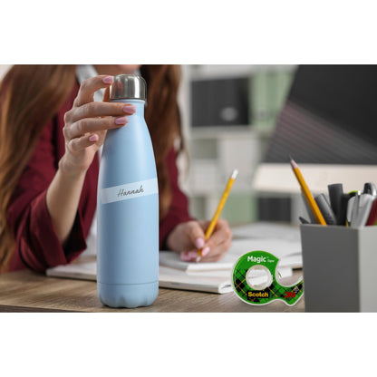 Eine Person mit einer blauen Flasche mit der Aufschrift "Hannah" sitzt an einem Schreibtisch mit Notizbüchern, Stiften und dem Scotch® Magic™ Unsichtbares Klebeband 8-1915R3/2 Aktionspackung von 3M - ideal zum Basteln. Im Hintergrund befinden sich Büroregale und ein unscharfer Arbeitsbereich.