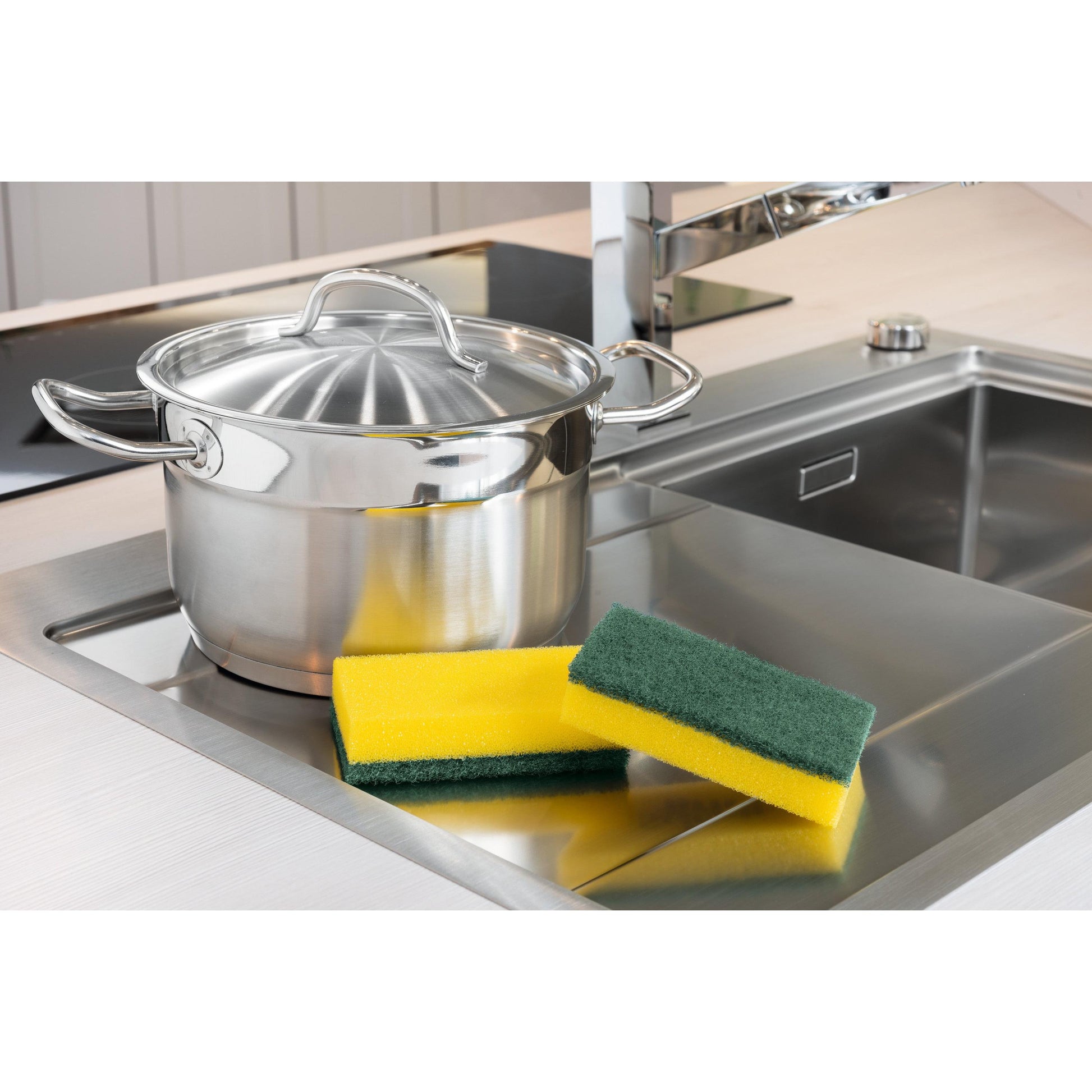 Ein Edelstahltopf mit Deckel steht auf einer modernen Küchenspüle, daneben liegen zwei 3M Deutschland GmbH Scotch-Brite® Classic Reinigungsschwamm XXL (6 Stück pro Packung) auf der Arbeitsplatte. Im Hintergrund ist ein verchromter Wasserhahn zu sehen.