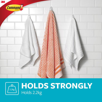 Trei prosoape atârnă de cârlige pentru prosoape de baie Command™ de la 3M Deutschland GmbH - un prosop cu dungi portocalii și albe între două prosoape albe - pe un perete cu faianță albă. Text: "HÄLT STARK Hält 2,2 kg." Logourile Command și 3M sunt vizibile.