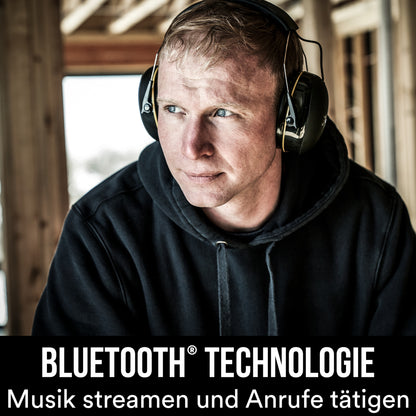 Ein Mann trägt drinnen einen schwarzen Hoodie und den 3M™ WorkTunes™ Connect Kapselgehörschutz 90543E (SNR 31 dB) von 3M Deutschland GmbH. Text: "Bluetooth Gehörschutz. Musik streamen und Anrufe tätigen.