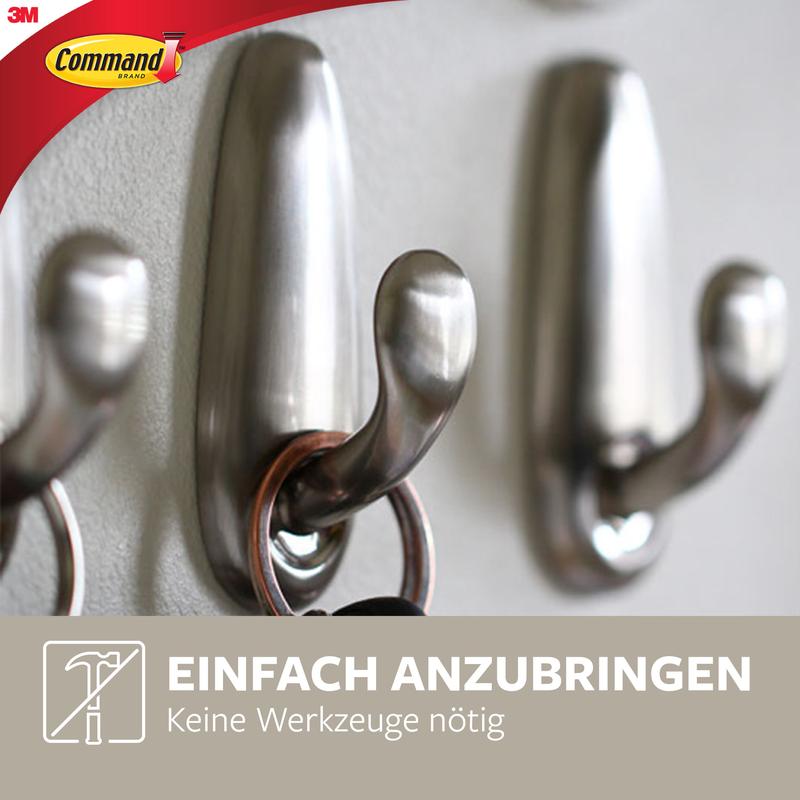 Trei cârlige metalice Command™ „clasic” de la 3M Deutschland GmbH sunt montate pe un perete, unul ținând chei. Imaginea arată „Ușor de aplicat, fără unelte necesare” cu logo-ul 3M în colț.