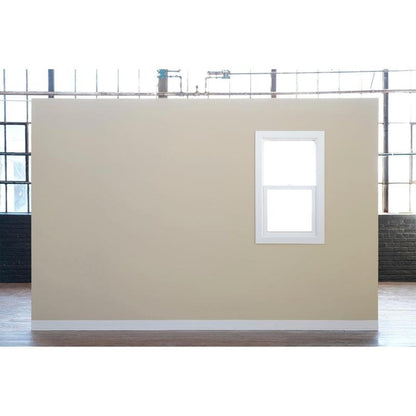 Un perete bej cu o fereastră încadrată în alb se află în fața unor ferestre mari industriale - ideal pentru vopsire cu banda de mascare Scotch® Classic, 24 mm x 50 m, de la 3M Deutschland GmbH (70% PEFC, SGSCH-COC-110078) - într-o cameră mare cu podea din lemn.