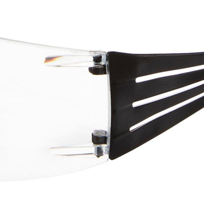 Prim-plan al balamalei ochelarilor de protecție pentru citit 3M™ SecureFit™ de la 3M Deutschland GmbH, arătând vizorul clar atașat de o braț negru cu trei decupaje alungite.