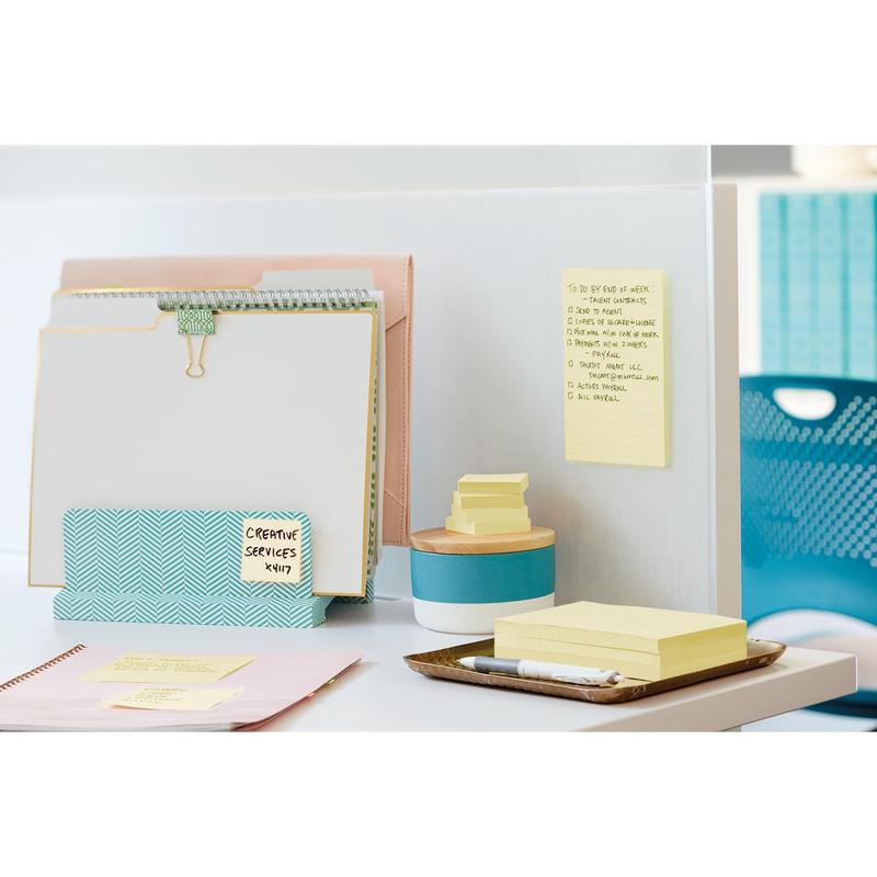 Un birou ordonat cu dosare, un bloc de notițe, 3M Post-it® Super Sticky Notes Galben (47,6x47,6 mm, 21+3 Promo Pack), un pix, o cutie mică, o tabletă; o listă de sarcini este atașată pe perete despărțitor. Un scaun de birou albastru este în fundal.