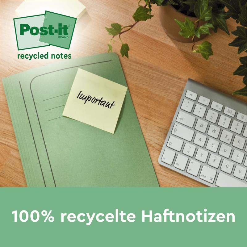 Un dosar verde cu un Post-it® Notes de reciclare galben, 76x127mm, 100 foi/bloc de la 3M Deutschland GmbH este așezat pe un birou de lemn lângă o tastatură albă și o plantă. Notițele sunt 100% PEFC (SGSCH-PEFC-COC-110078) și ecologice.