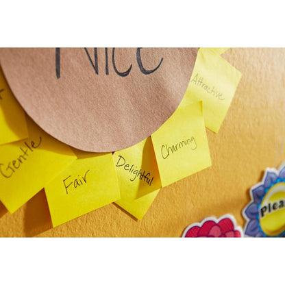 Notițe Post-it® Recycling (38 mm x 51 mm, 100 foi/bloc, 100% PEFC) de la 3M Deutschland GmbH, etichetate cu adjective pozitive precum „blând”, „corect” și „fermecător”, sunt aranjate circular pe un perete galben în jurul unei hârtii maro cu inscripția „drăguț”.