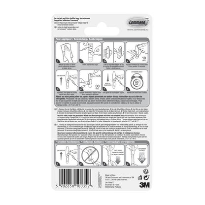 Partea din spate a ambalajului cârligelor metalice Command™ „clasic” (3M Deutschland GmbH) cu instrucțiuni ilustrate, multilingve de aplicare și îndepărtare, precum și un cod de bare în partea de jos.