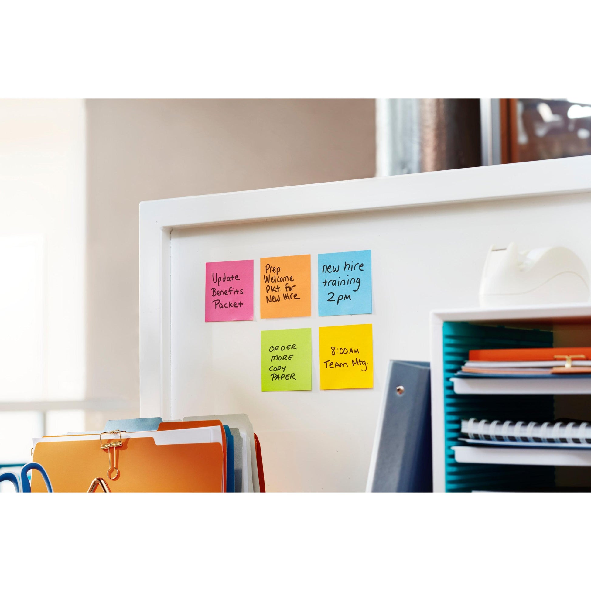 Eine weiße Trennwand zeigt 3M Deutschland GmbH Post-it® Super Sticky Notes (76 mm x 127 mm, 90 Blatt/Block, 100% PEFC) mit Aufgaben wie der Aktualisierung von Leistungspaketen und der Planung von Teamsitzungen. Büromaterialien sind in der Nähe.